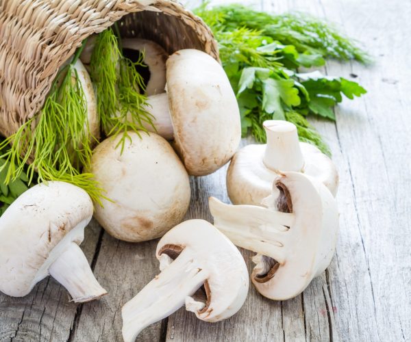 Mushrooms,In,Basket,,Rustic,Wood,Background